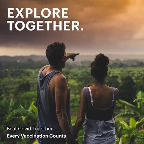 Couple overlooking a green valley with Explore Together and Beat Covid Together vaccination messaging.