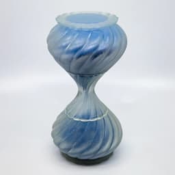 Light blue frosted glass hourglass vessel with a twisted diagonal swirl pattern.