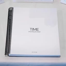 White spiral-bound book cover titled TIME: Unwinding the Spiral by Gian Cambridge.