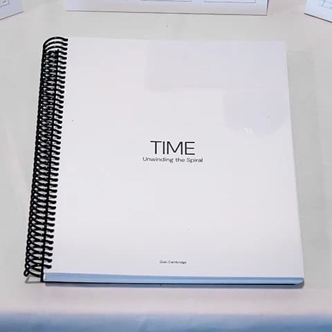 White spiral-bound book cover titled TIME: Unwinding the Spiral by Gian Cambridge.