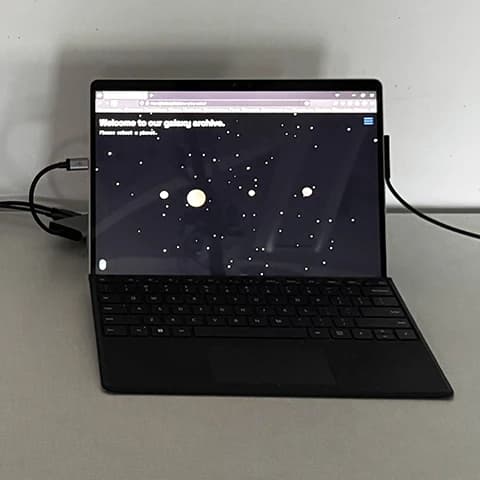 Tablet showing the Planetary Archive site with selectable planet icons on a star field.